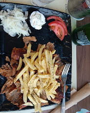 Pork gyros plate with fries, onions and tomato