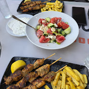 Table with souvlaki, salad and fries